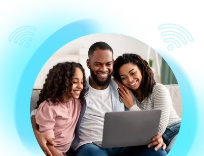 Família sorrindo no sofá olhando um notebook com o logo da Premier Fibra